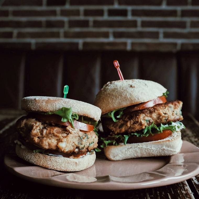 Krokante kipburger met sla en tomaat op een zacht broodje